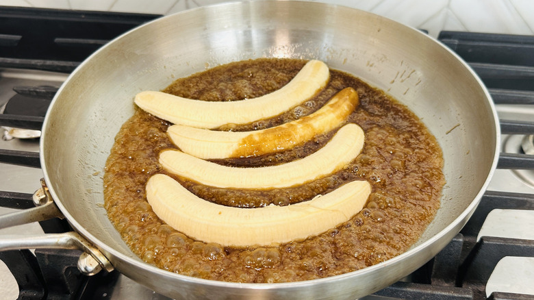 Bananas cooking in caramel in pan