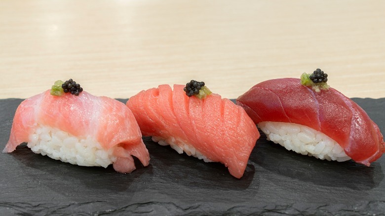 Three nigirizushi with different cuts of fish and wasabi