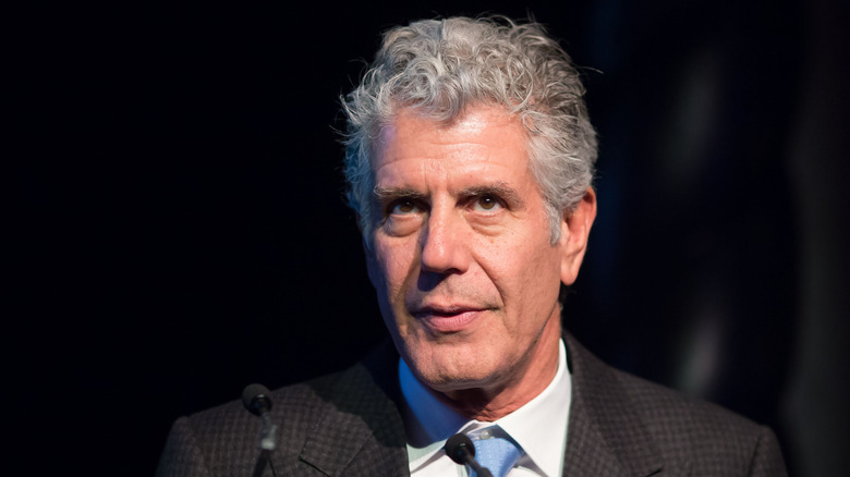 Anthony Bourdain in front of a microphone