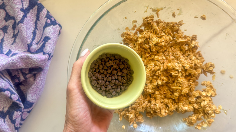 hand adding chocolate chips