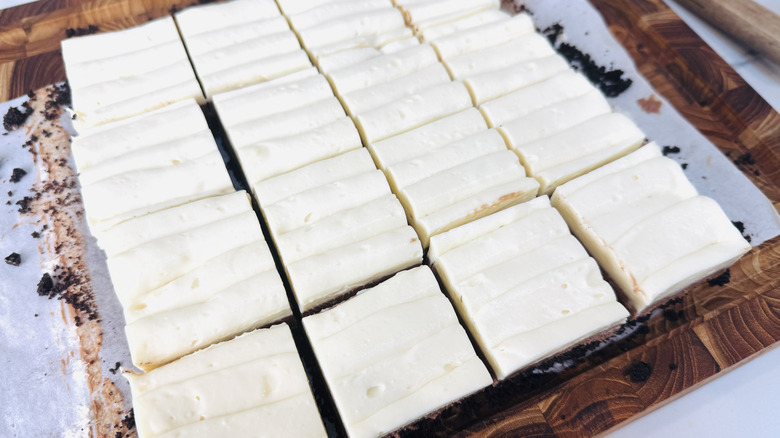 No-bake triple chocolate cheesecake bars on cutting board