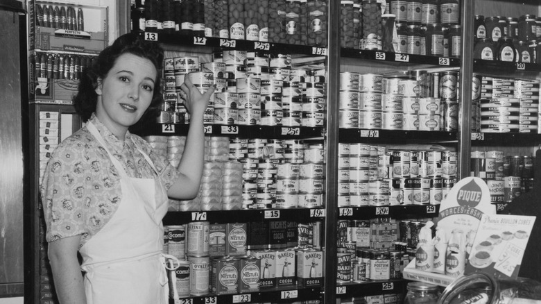 Unlabeled canned foods sit haphazardly on a green surface