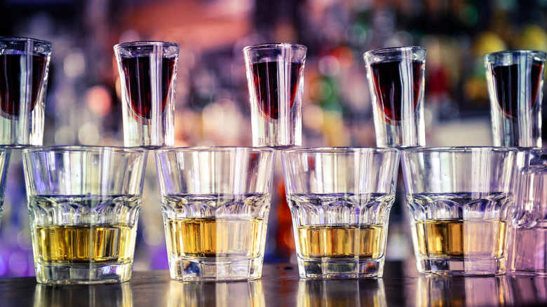 Four pint glasses with Red Bull and five shot glasses balances on top with Jagermeister between them