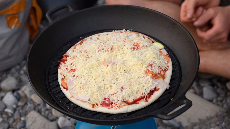 Pizza cooking in cast iron pan