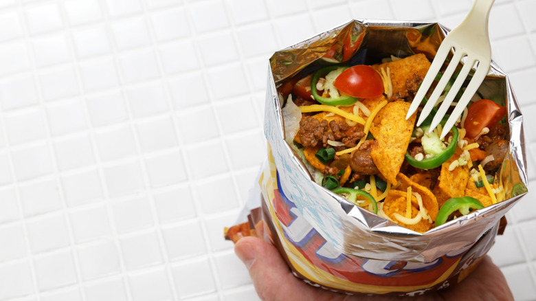 Someone holding a bag of walking taco