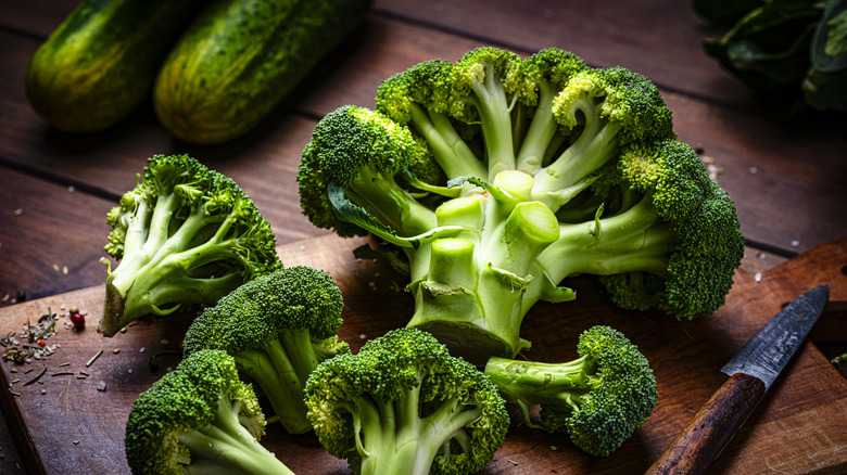Broccoli is arranged on a cutting board.