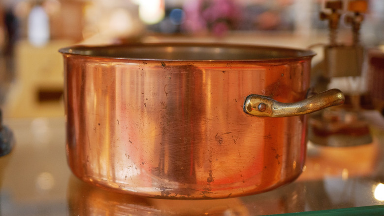 A copper pot with obvious signs of wear and tear
