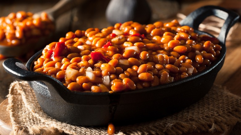 Barbecue baked beans in a cast-iron skillet.