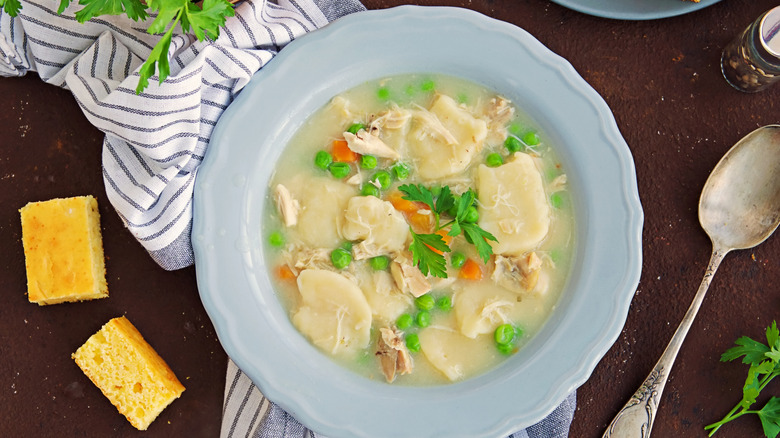 A bowl of soupy peas and dumplings.