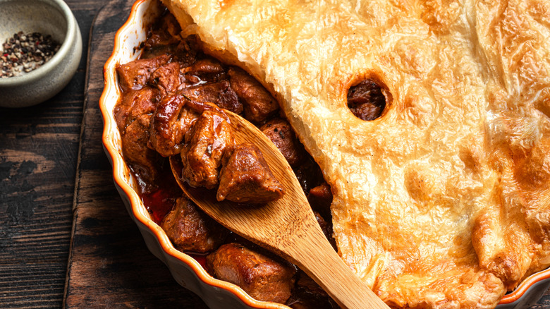 bison pot pie with hunks of meat on a wooden spoon