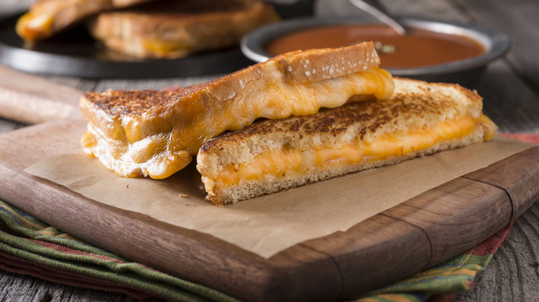 Two halves of a grilled cheese on a cutting board.