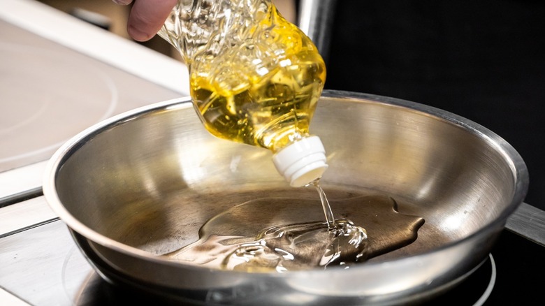 A stainless steel pan with signs of use set atop a stove.