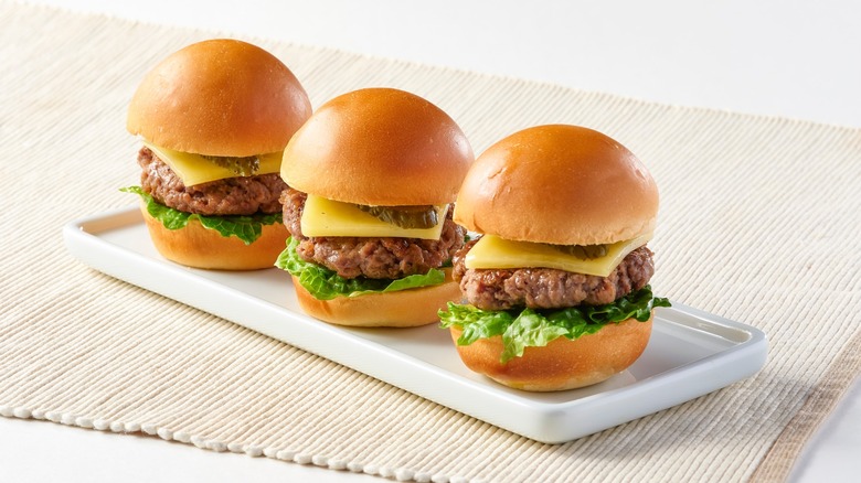 Three cheeseburger sliders on plate