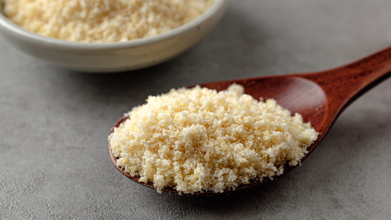 Parmesan popcorn seasoning powder on a dark wood spoon
