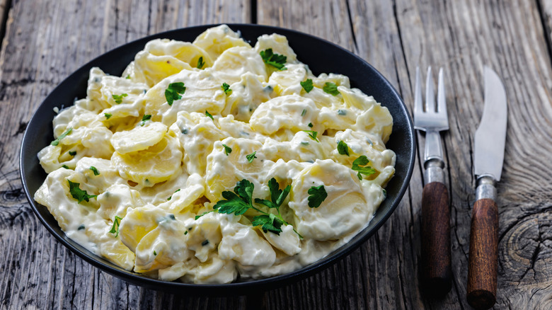 A creamy potato salad topped with fresh parsley