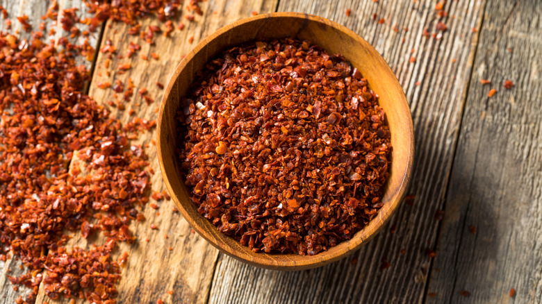 A wooden bowl of Aleppo pepper flakes