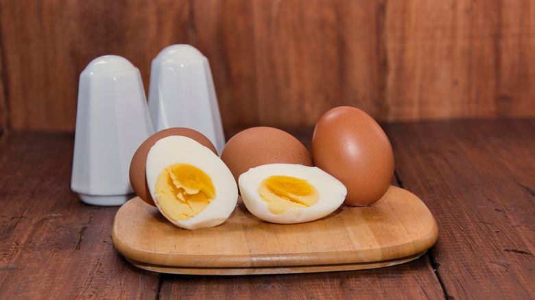 hard boiled eggs on a cutting board with an egg cut open
