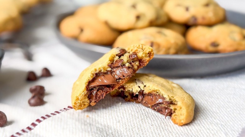 Nutella-stuffed chocolate chip cookie broken in half with soft Nutella in the center