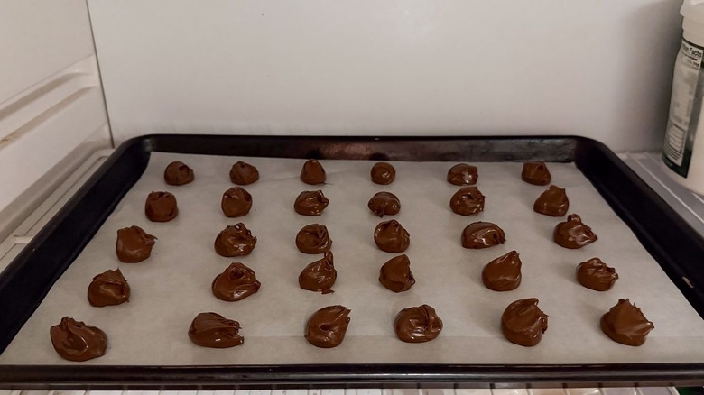 Nutella scoops on parchment-lined baking sheet in freezer