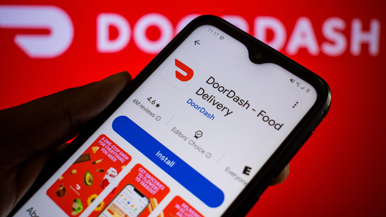 Someone holding a phone with the Door Dash delivery app on screen