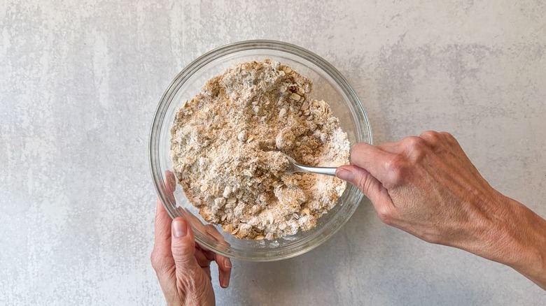Stirring the dry ingredients for crumb cake topping with a fork in glass bowl