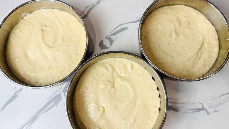 Cake batter in three round pans