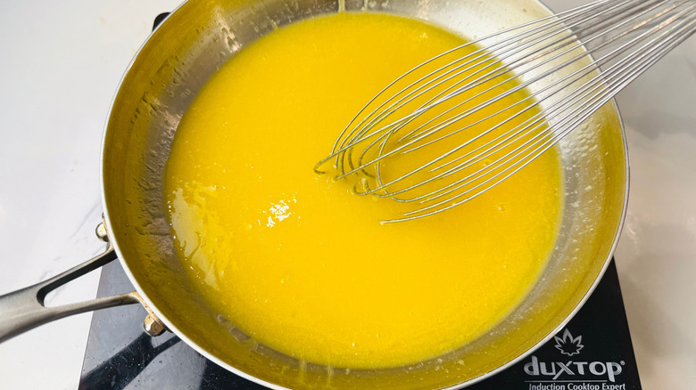 Whisking butter and egg yolk mixture in skillet