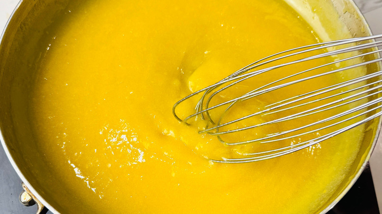 Whisking butter and egg yolk mixture in skillet