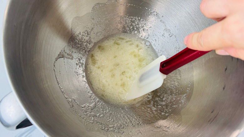 Rubber spatula stirring egg white mixture in bowl