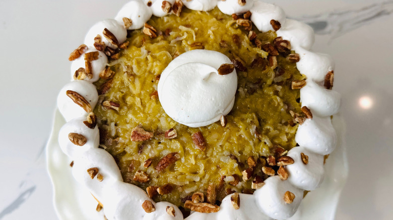 Lane cake topped with meringue frosting and pecans