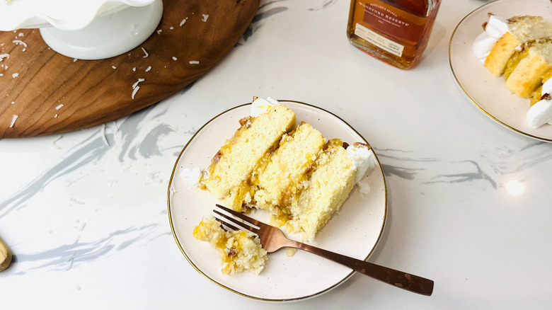 Slice of lane cake on plate with fork