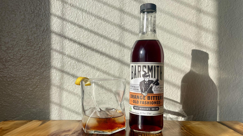 Bottle of Barsmith Orange Bitters Old Fashioned with a cocktail made
