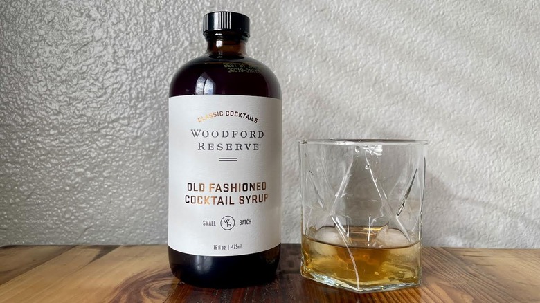 Bottle of Woodford Reserve Old Fashioned Cocktail Syrup with a cocktail made alongside