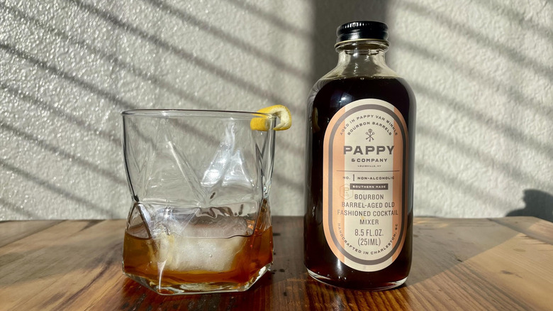 Bottle of Pappy & Company Bourbon Barrel-Aged Old Fashioned Cocktail Mixer with a cocktail made