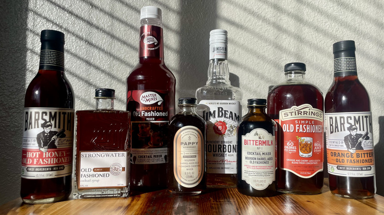 Collection of various Old Fashioned cocktail mixes with a bottle of Jim Beam