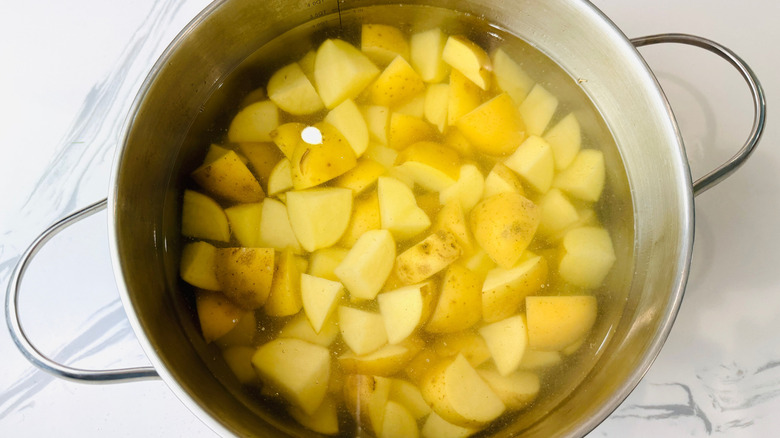 Chopped potatoes in pot of water