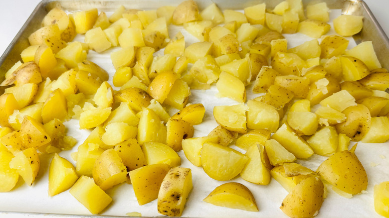 Potatoes spread out on baking sheet