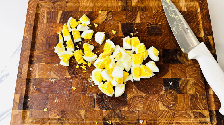 Chopped hard boiled eggs on wooden board