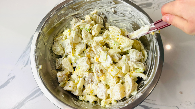 Mixing dressing into potato salad