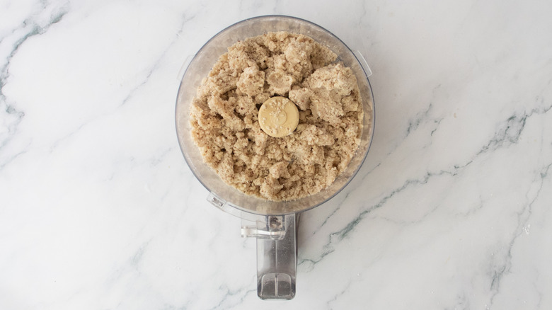 Crumbly pecan shortbread mixture in a food processor