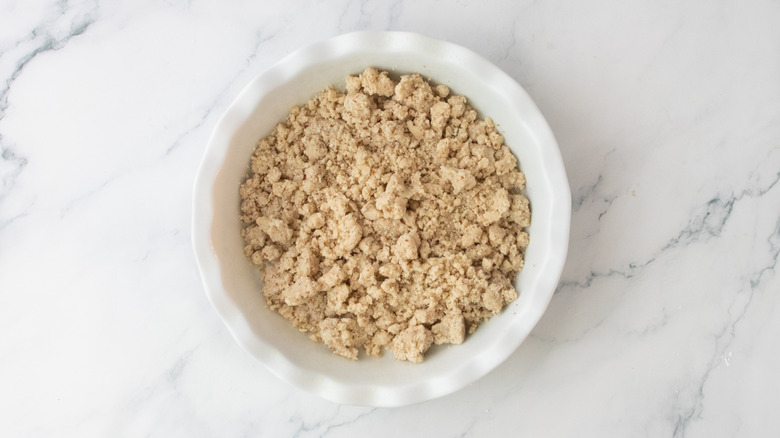 Crumbly pecan shortbread mixture in a pie pan