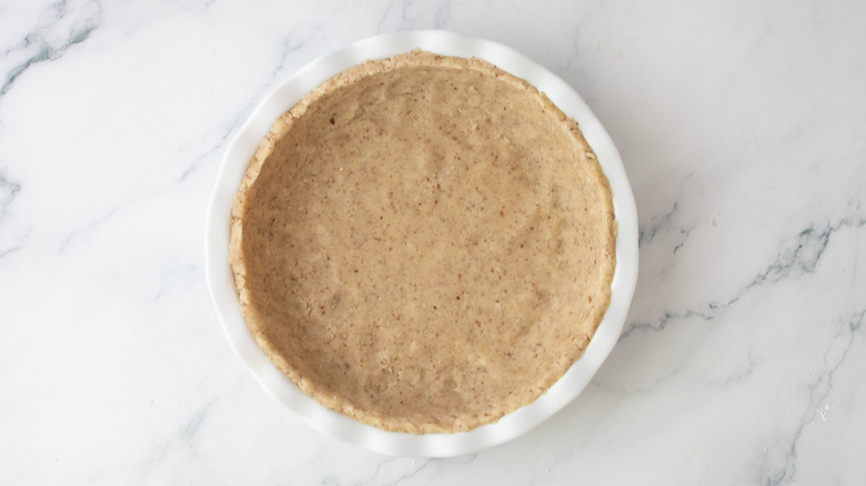 Raw shortbread dough pressed into a pie pan