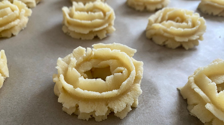 Freshly pressed spritz cookies on baking sheet