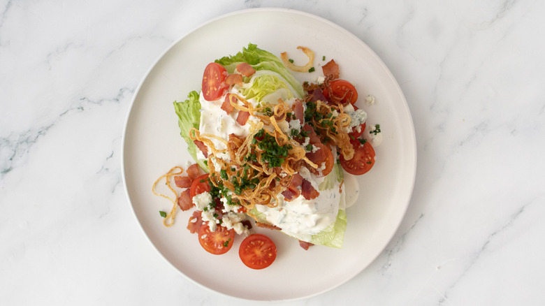 Iceberg wedge topped with crispy onions, bacon, and chives