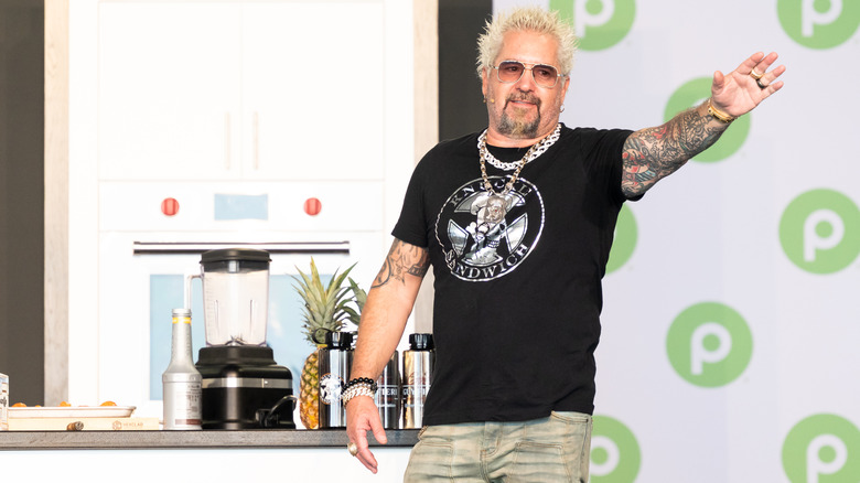 Guy Fieri on stage, waving at the audience
