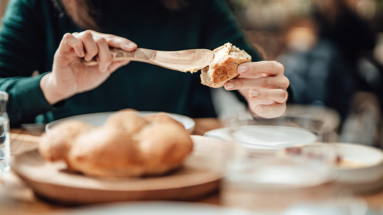 Woman spreading butter on a piece of bread