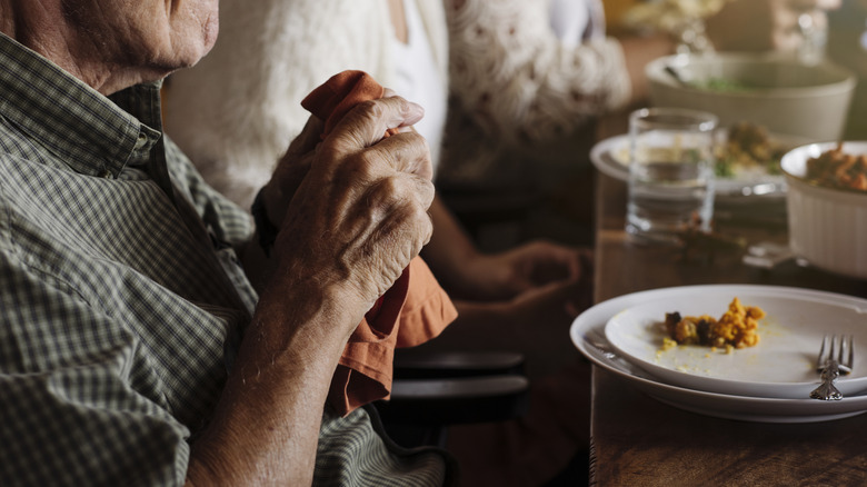 Man moving dinner napkin to lap at a restaurant