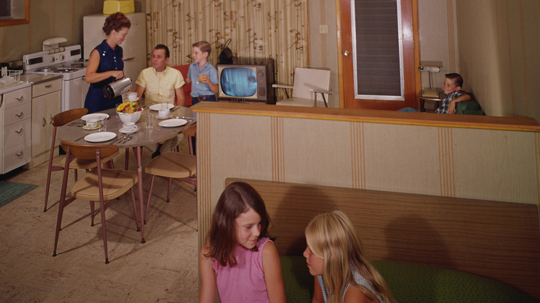 A family eating dinner at an oval table with modern chairs