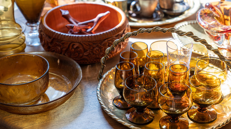 A collection of vintage amber glassware on a wooden table