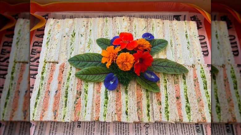 Close-up of ribbon sandwiches served at a modern day event with decorative flowers on top
